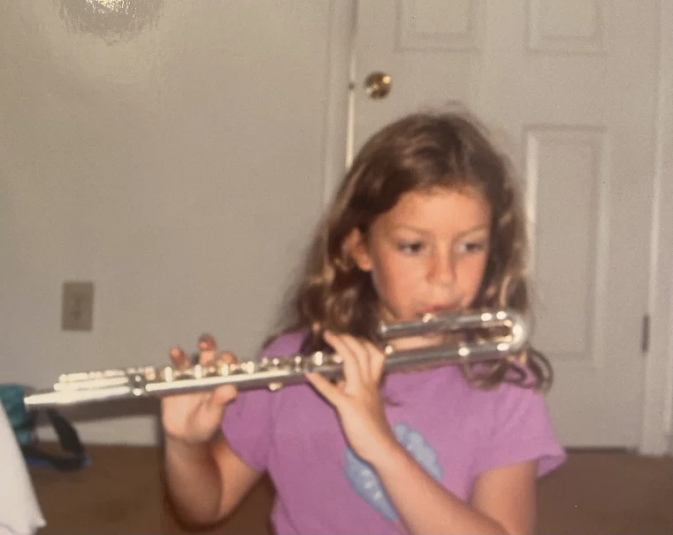 Shea playing flute as a child, 2003